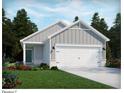 Gray house with white garage door and landscaping at 835 Cypress Preserve Circle, Longs, SC 29568