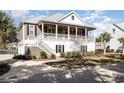 Inviting two-story home with double porches, enhanced by meticulous landscaping and serene surroundings at 76 Eagle Pass Dr., Murrells Inlet, SC 29576