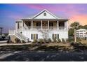 Charming two-story home featuring double porches and classic architectural details, set against a vibrant sky at 76 Eagle Pass Dr., Murrells Inlet, SC 29576