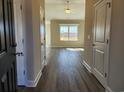 Inviting hallway featuring wood floors and an open view to a sunlit living area with large windows at 2814 Daisy Rd., Loris, SC 29569