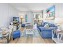 Cozy living room featuring a comfortable blue couch, beach decor, and a sliding glass door at 4201 N Ocean Blvd. # 2M, North Myrtle Beach, SC 29582