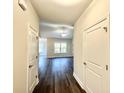 Inviting hallway featuring sleek, dark hardwood floors and a view into the living area with a large window at 6944 Highway 66, Loris, SC 29569
