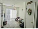 Bright living room with sliding glass door, neutral carpet, modern lighting, and a ceiling fan at 100 G Myrtle Greens Dr. # G, Conway, SC 29526