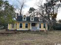 Two-story yellow house with white trim and a front porch at 2708 Main St., Loris, SC 29569