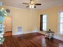 Spacious living room with hardwood floors, bright windows, and a ceiling fan at 306 E Godbold St., Marion, SC 29571