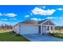 New construction home showcasing a two-car garage and an inviting front porch at 60 Cape Point Dr., Conway, SC 29527