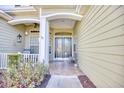 A welcoming front porch showcasing a seating area and decorative glass front doors with an arched entryway at 190 Sugar Loaf Ln., Murrells Inlet, SC 29576