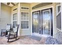 Inviting front porch featuring decorative front doors, a tiled floor, and comfortable rocking chairs at 190 Sugar Loaf Ln., Murrells Inlet, SC 29576