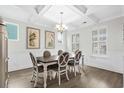 Elegant dining room featuring wainscotting, coffered ceilings, and natural light from shuttered windows at 3126 White Jasmine Dr., Little River, SC 29566