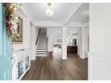 Bright foyer with hardwood floors, staircase, and open view to the modern kitchen and living spaces at 3126 White Jasmine Dr., Little River, SC 29566