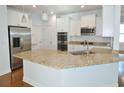 Modern kitchen featuring granite countertops, stainless steel appliances, white cabinetry, and tile backsplash at 64 Summerlight Dr., Murrells Inlet, SC 29576