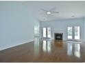 Bright living room featuring vaulted ceiling, fireplace, hardwood floors, and French doors leading to outdoor spaces at 64 Summerlight Dr., Murrells Inlet, SC 29576