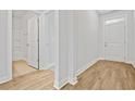 Bright hallway with wood-look flooring, white trim, an entry door and visible bathroom doorway at 1217 Nw Calabash Station Blvd., Calabash, NC 28467
