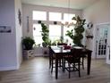 Bright dining room featuring lots of light, beautiful plants and modern luxury vinyl plank flooring at 3070 Sutherland Dr., Little River, SC 29566