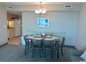 Open dining area with a modern chandelier, seating for six, and neutral decor at 2301 S Ocean Blvd. # 1002, North Myrtle Beach, SC 29582