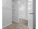 A well-lit closet with wire shelves leads to a bright bathroom with glass shower at 1518 Clubstone Dr., Conway, SC 29526