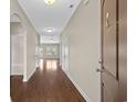 Long hallway with hardwood floors, archways, and neutral paint, creating a welcoming and spacious entrance into the home at 1711 Sapphire Dr., Longs, SC 29568
