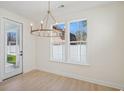 Bright dining room with a modern chandelier, large windows, and access to an outdoor space at 2624 Hillbourne Loop, North Myrtle Beach, SC 29582