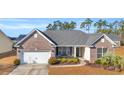 Inviting home with a brick facade, manicured landscaping, and a two-car garage on a sunny day at 1139 Parish Way, Myrtle Beach, SC 29577