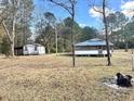 A quaint outbuilding and a home with a screened porch are nestled on a vast, wooded lot at 1451 Cane Branch Rd., Loris, SC 29569