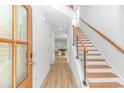 Bright entryway with wood flooring, staircase with wood treads and metal railings, and a view into the living area at 210 26Th Ave. S, Myrtle Beach, SC 29577