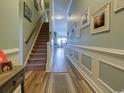 Inviting hallway with stairs leading to upper level and decorative wainscoting at 5910 Lazio Ct. # 5910, Myrtle Beach, SC 29579