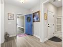 Bright foyer features a striking blue door, wood-look flooring, and elegant decor at 7246 Sarteano Dr., Myrtle Beach, SC 29572