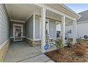 Inviting front porch with rocking chairs, stylish columns, and an ADT security system sign at 7246 Sarteano Dr., Myrtle Beach, SC 29572