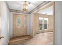 Bright entryway with wood-look floors, decorative trim, and a front door with decorative glass inserts at 74 Brandy Ln., Georgetown, SC 29440