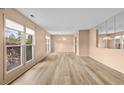Bright living room with large windows, wood-look floors, and mirrored wall accents at 74 Brandy Ln., Georgetown, SC 29440