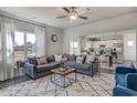 Comfortable living room featuring a plush gray sectional sofa, a stylish rug, and an open view of the kitchen at 896 Agostino Dr., Myrtle Beach, SC 29579