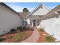 Inviting front entrance featuring a patterned walkway, manicured landscaping, and a classic wooden door at 126 Pickering Dr., Murrells Inlet, SC 29576
