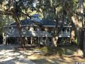 Charming raised beach house with covered porch, surrounded by mature trees at 187 Alston Rd., Pawleys Island, SC 29585