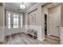 Inviting foyer with wood floors, white wainscoting, bench and front door with frosted glass at 2023 Singing Palm Loop, Little River, SC 29566