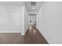 Hallway with hardwood floors, white walls, leading to an open space and staircase, creating a seamless transition at 405 Cypress Springs Way, Little River, SC 29566
