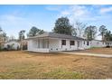 A single-story brick home with dark trim features a covered porch and yard at 412 E Melrose St., Mullins, SC 29574