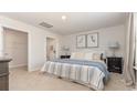 Bright main bedroom with neutral decor, a large bed, and an ensuite bathroom at 218 Carver Willow Dr., Loris, SC 29569