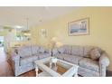 A bright living room with two sofas, a glass coffee table, and an open view to the dining area at 4240 Coquina Harbour Dr. # E-4, Little River, SC 29566