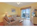 Cozy living room with comfortable seating and sliding glass doors to a balcony with harbor views at 4240 Coquina Harbour Dr. # E-4, Little River, SC 29566