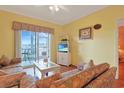 Comfortable living room featuring a balcony overlooking the water, and a television at 4240 Coquina Harbour Dr. # E-4, Little River, SC 29566