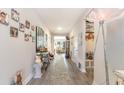 Long hallway with light grey wood flooring, decorated with photos and leading to the living room at 5037 Sassari St., Myrtle Beach, SC 29579