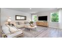 Bright living room showcasing neutral tones, a comfortable sofa, a large TV, and natural light from the windows at 562 Haven View Way, Murrells Inlet, SC 29576
