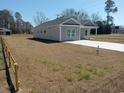 Gray home featuring a well-manicured front yard with an expansive driveway at 941 Hickman Rd., Tabor City, NC 28463