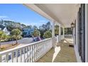 Spacious front porch with white railings, offering views of the neighborhood at 112 Cockle Shell Ct., Pawleys Island, SC 29585