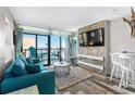 Living room featuring a blue couch, balcony access, and stone accent wall at 2311 S Ocean Blvd. # 1125, Myrtle Beach, SC 29577