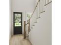 Light-filled entryway with modern staircase and black front door at 890 Foxtail Dr. # D-40, Longs, SC 29568