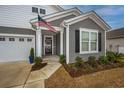 Front entry of gray and white house, featuring a porch and American flag at 2548 Brescia St., Myrtle Beach, SC 29579