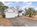 White house with double garage and driveway, surrounded by trees at 1228 Lanterns Rest Rd., Myrtle Beach, SC 29579