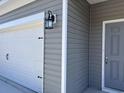 Close-up of the home's exterior, highlighting the siding, garage door, and front door at 301 Palmetto Sand Loop, Conway, SC 29527