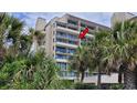 Coastal condominium with a private balcony showcasing ocean views and lush tropical foliage at 4719 S Ocean Blvd. # 609, North Myrtle Beach, SC 29582